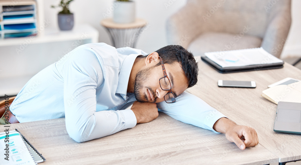 Burnout, sleeping and tired with an overworked business man asleep at his desk in the office. Exhausted, fatigue and dreaming with a young male employee napping on a table at work after working late Burnout, sleeping and tired with an overworked business man asleep at his desk in the office. Exhausted, fatigue and dreaming with a young male employee napping on a table at work after working late