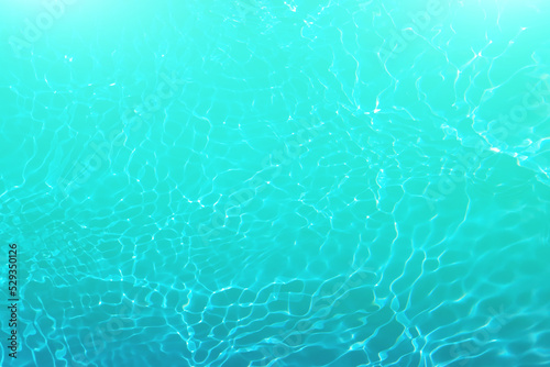 Defocus blurred transparent blue colored clear calm water surface texture with splashes and bubbles. Trendy abstract nature background. Water waves in sunlight with copy space. Blue watercolor shining