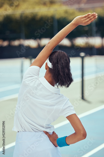 Fitness, tennis and stretching of a woman in motivation for training, exercise and sports workout on a court. Active, athletic and fit female in sports arm stretch for game or match in the outdoors