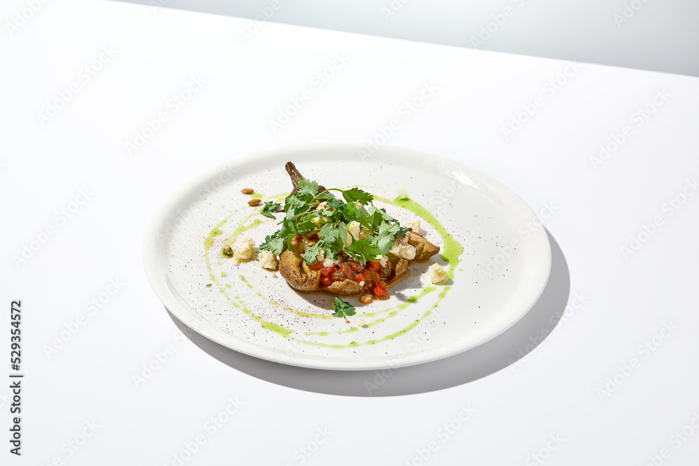 Baked eggplant with cheese on white table with harsh shadows. Aesthetic italian food - baked aubergine on white plate. Stuffed eggplant in minimal style. Stuffed aubergine in vegan menu. Baked eggplant with cheese on white table with harsh shadows. Aesthetic italian food - baked aubergine on white plate. Stuffed eggplant in minimal style. Stuffed aubergine in vegan menu.