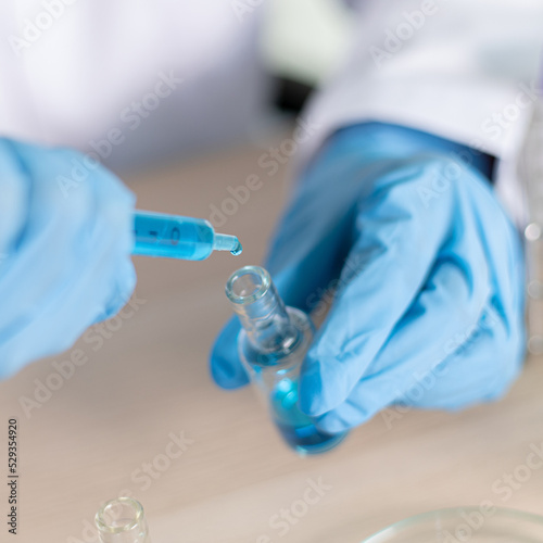 Scientists are carrying blue chemical test tubes to prepare for the determination of chemical composition and biological mass in a scientific laboratory, Scientists and research in the lab Concept.