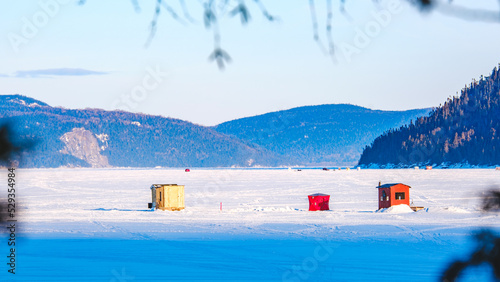 View on the colorful ice fishing hust installed on the frozen Saguenay fjord in winter in Quebec (Canada) photo