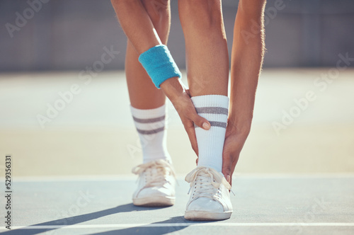 Tennis athlete with ankle injury, pain and hurt on a court after training, workout or practice outdoor. Professional sport person with accident after fitness exercise, game or match at a sports club