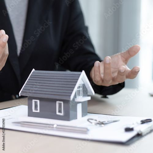 Real estate agent or sales manager has offered home sales and explained the terms of signing the house purchase contract and free home insurance, Finance and after-sales service concept.