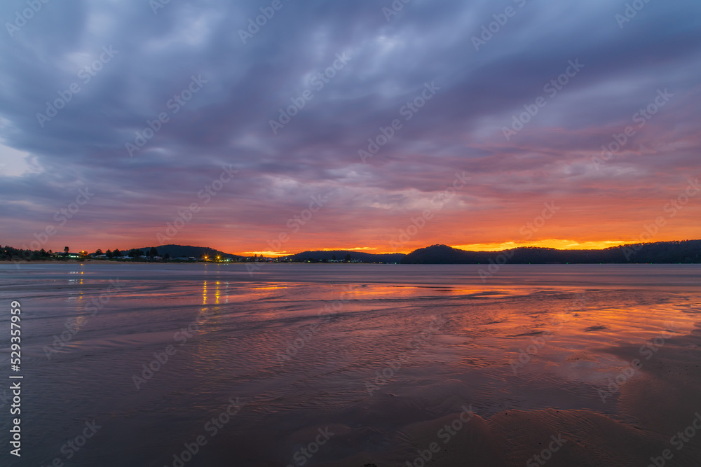Obraz premium Colourful cloud filled sunrise at the seaside