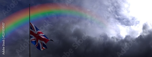 UK flag in half mast and rainbow. United Kingdom flag against dark dramatic cloudy sky with colorful rainbow. 3D render British flag illustration