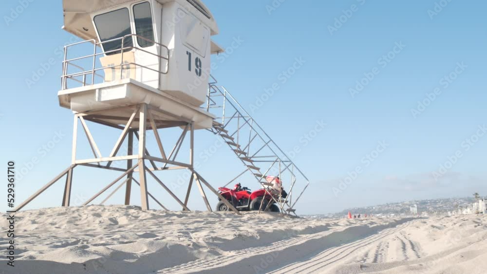 Lifeguard stand or life guard tower hut, surfing safety on California beach, USA. Summer pacific ocean aesthetic. Rescue station, coast lifesavers wachtower or house on sand. Red ATV on Mission beach. Lifeguard stand or life guard tower hut, surfing safety on California beach, USA. Summer pacific ocean aesthetic. Rescue station, coast lifesavers wachtower or house on sand. Red ATV on Mission beach.