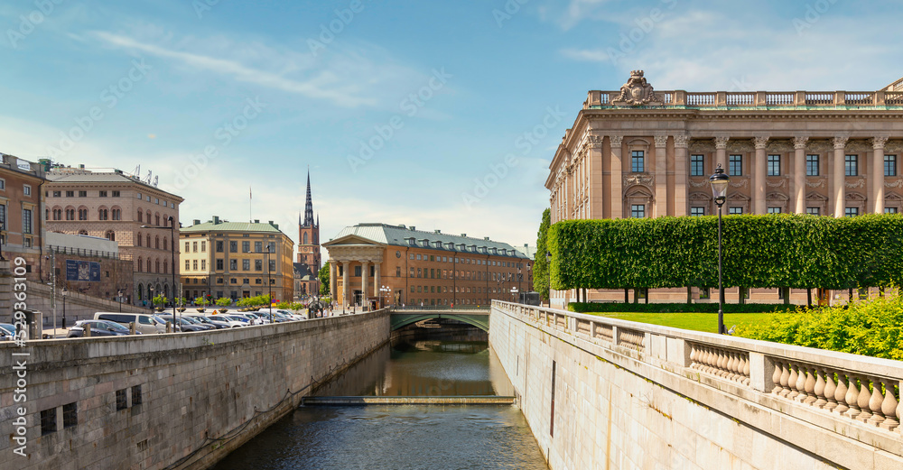 Norrstrom river with the Swedish Parliament on the right, Central authority of Sweden, or Sveriges Riksdag, and tower of Klara Church in the far end, Old town, or Gamla Stan, Stockholm, Sweden
