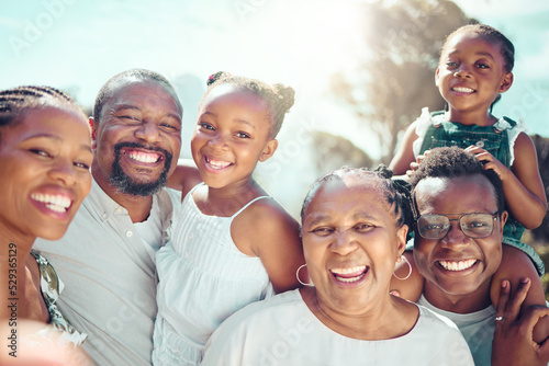 Portrait, happy black big family and love as they smile on vacation, trip or holiday. Ancestry, African people or grandparent, fathers and mother with kids together in the shining sun or sunshine. photo