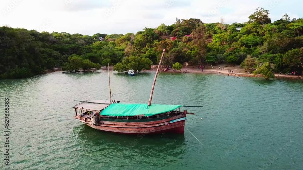Traditional Wooden Dhow Boat Floating Near The Beach On The Coast Of Kenya. - aerial Traditional Wooden Dhow Boat Floating Near The Beach On The Coast Of Kenya. - aerial