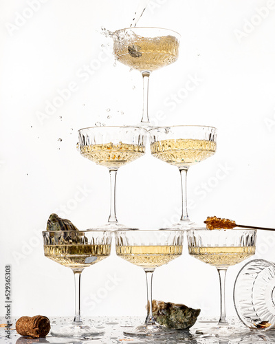 A large pyramid tower of champagne glasses alcohol cocktail with splash of berries oyster isolated on white background party