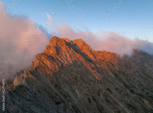 Sunrise in the Dolomites mountains with mist and clouds in the early morning. Fog rolling around the mountain peaks. 