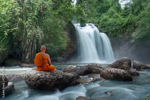 Buddha monk practice meditation at  waterfall in rainforest
