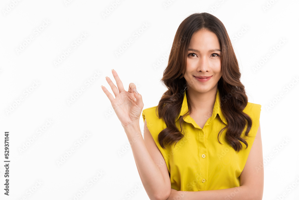A portrait of a beautiful asian woman in green shirt shows an OK sign and smilling isolated on white background. A portrait of a beautiful asian woman in green shirt shows an OK sign and smilling isolated on white background.