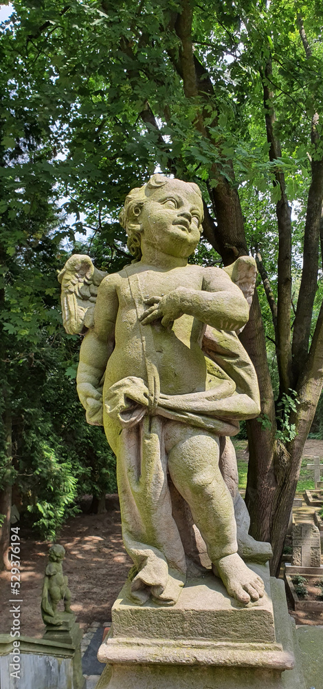 An old angel sculpture in front of the entrance to the old cemetery in Lower Silesia.