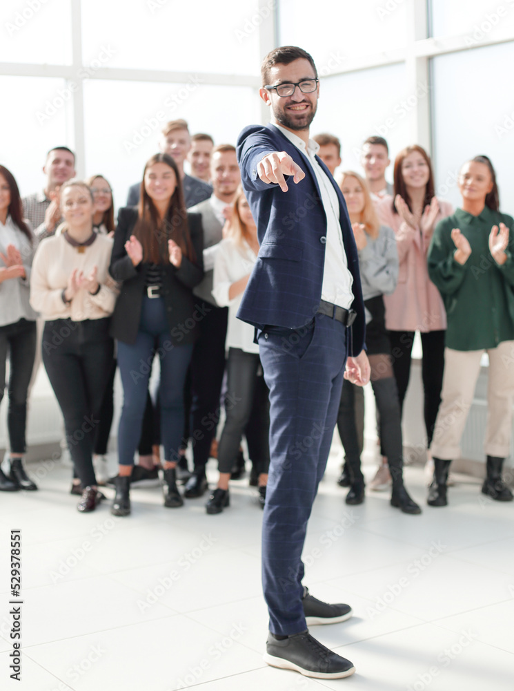 Fototapeta premium in full growth. smiling businessman pointing at you.