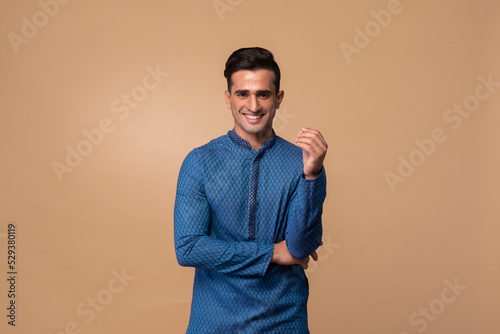 Young handsome Indian man wearing kurta with gifts in hand