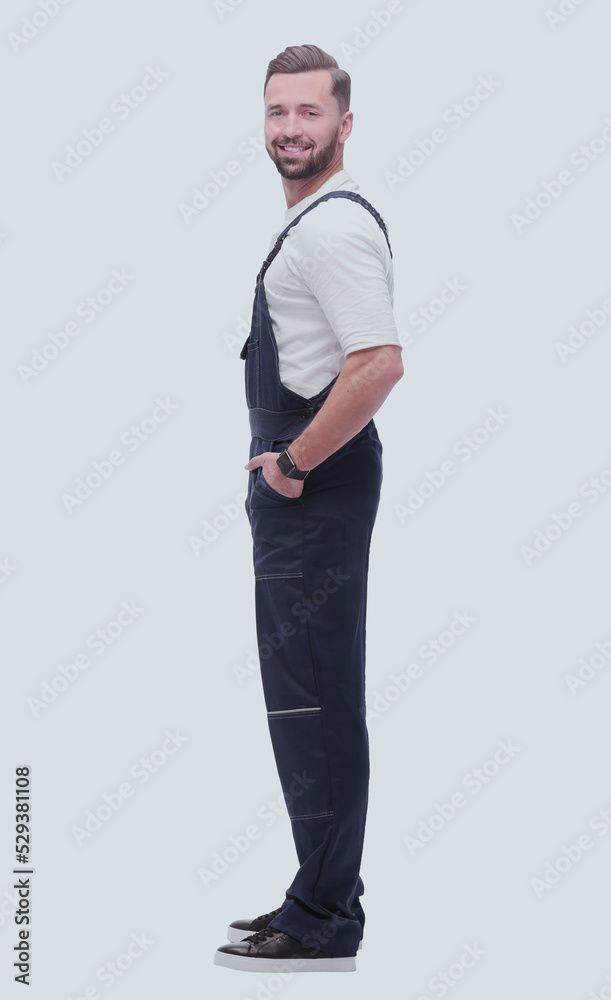 Fototapeta premium side view. smiling man in blue overalls. isolated on white