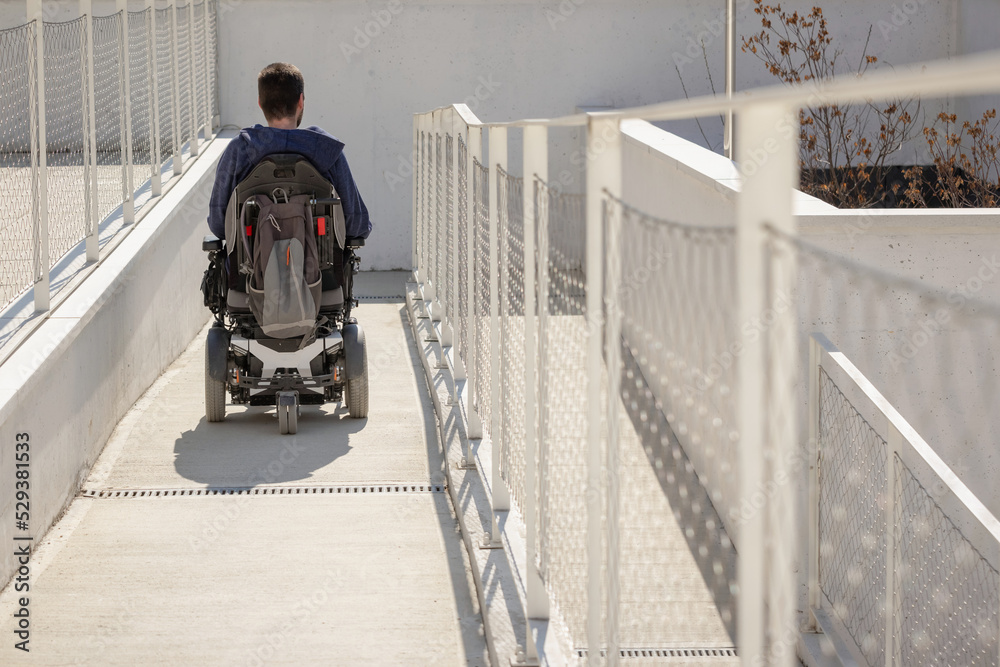 custom made wallpaper toronto digitalMan on wheelchair, approaching the building moving along an accessible ramp for persons with disability