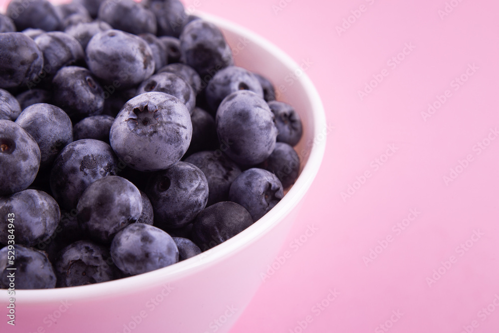 Blueberries on a macro scale. Dark berries in close-up. Ripe blueberries isolated on pink. Healthy, natural fruit.. Blueberries on a macro scale. Dark berries in close-up. Ripe blueberries isolated on pink. Healthy, natural fruit..