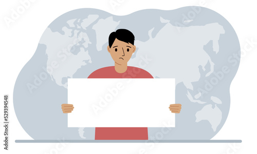 The concept of world attention. A man holds a white poster in his hands against the background of a world map.