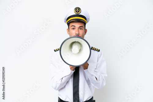 Airplane pilot over isolated white background shouting through a megaphone