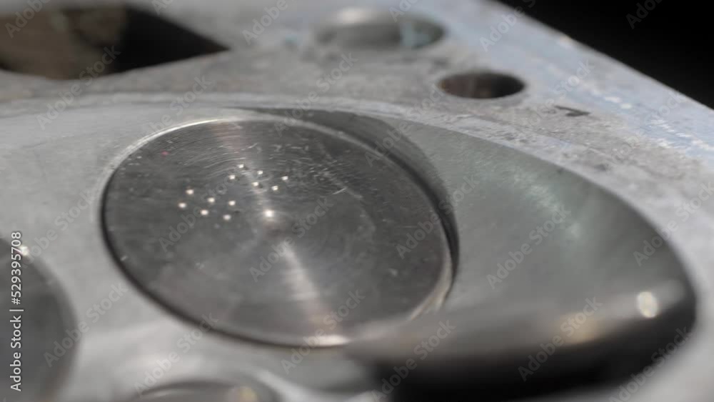 Old cylinder head block with valves. Close-up. Clean details. The movement of the camera on the slider is parallel to the details. Old cylinder head block with valves. Close-up. Clean details. The movement of the camera on the slider is parallel to the details.