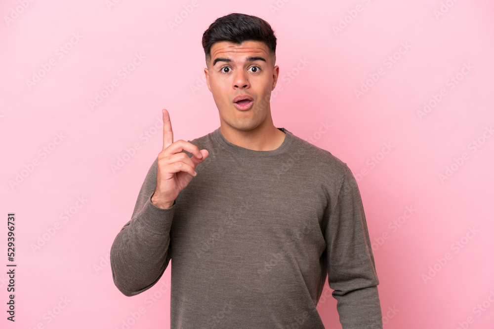 Young caucasian handsome man isolated on pink background intending to realizes the solution while lifting a finger up Young caucasian handsome man isolated on pink background intending to realizes the solution while lifting a finger up