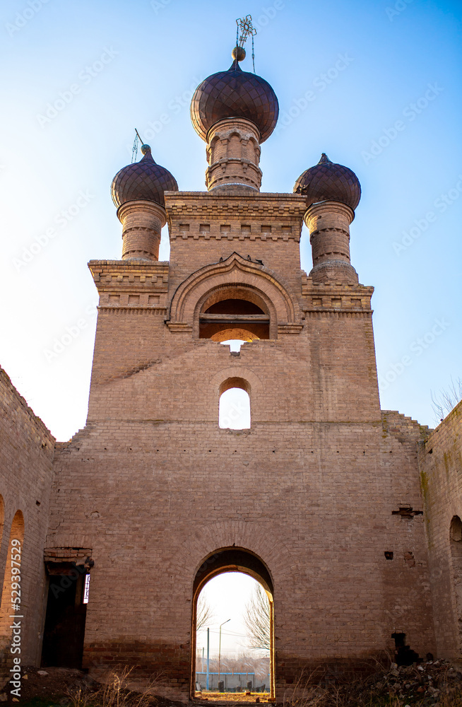 Obraz premium Old ruined church. Bent crosses and broken walls of the temple, ancient forged frames on the windows. Christian monastery.