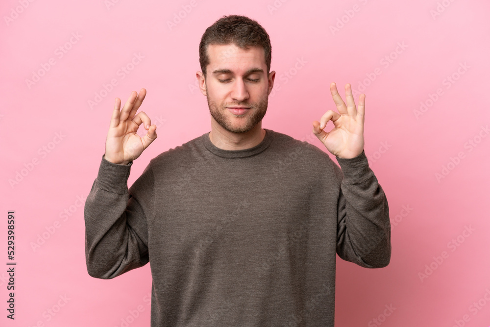 Young caucasian man isolated on pink background in zen pose Young caucasian man isolated on pink background in zen pose