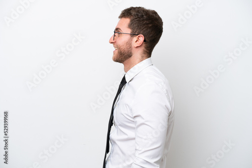 Young business caucasian man isolated on white background laughing in lateral position