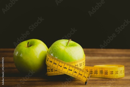 Green apples and measuring tape