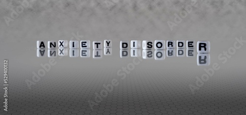 anxiety disorder word or concept represented by black and white letter cubes on a grey horizon background stretching to infinity