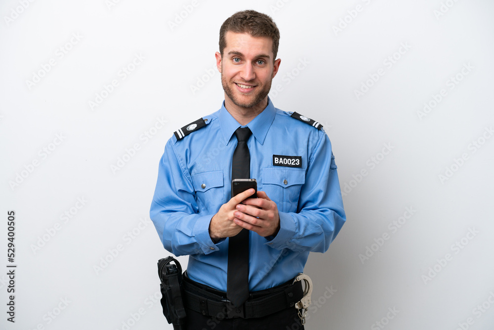 Young police caucasian man isolated on white background sending a message with the mobile Young police caucasian man isolated on white background sending a message with the mobile