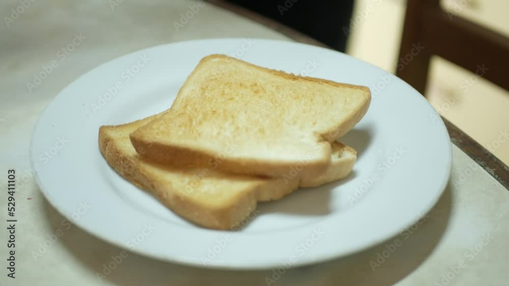 putting fresh toasted bread into white plate ready for healthy meal putting fresh toasted bread into white plate ready for healthy meal