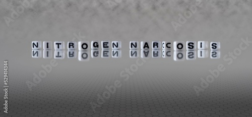 nitrogen narcosis word or concept represented by black and white letter cubes on a grey horizon background stretching to infinity