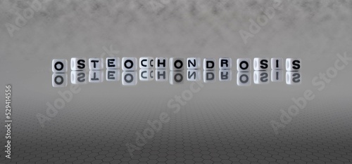 osteochondrosis word or concept represented by black and white letter cubes on a grey horizon background stretching to infinity