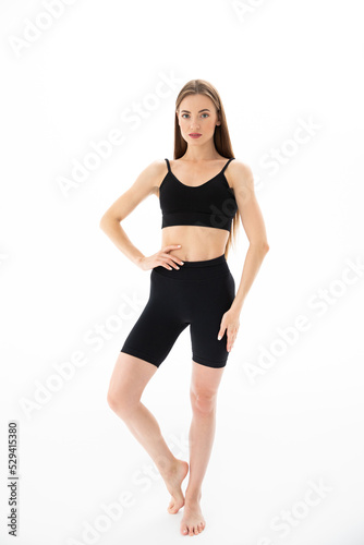 Slim sporty fitness young woman in black sportswear posing