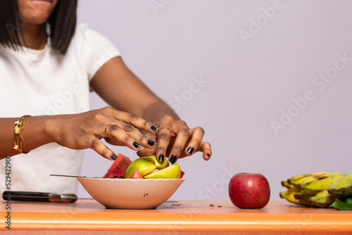 black lady cutting up some fruits