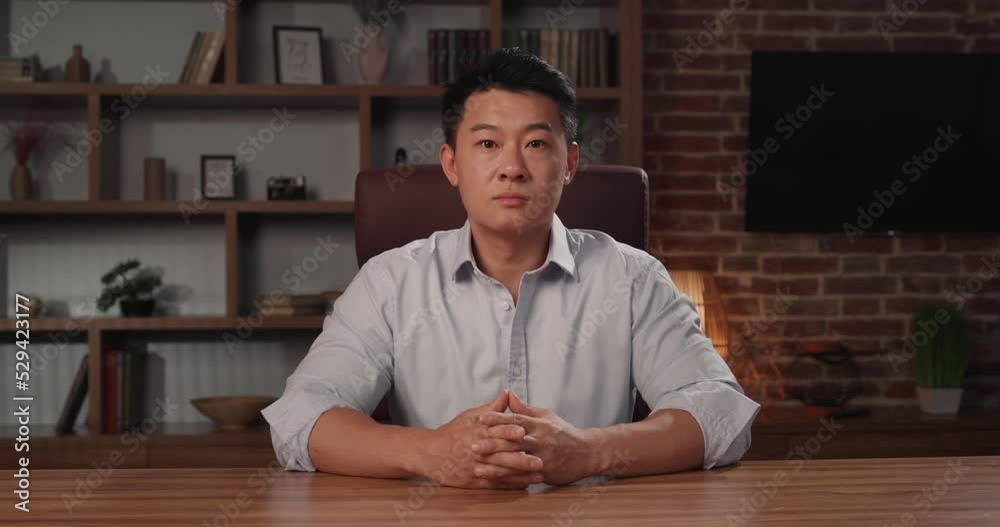 Portrait of Asian businessman in formal shirt sitting at home office Portrait of Asian businessman in formal shirt sitting at home office