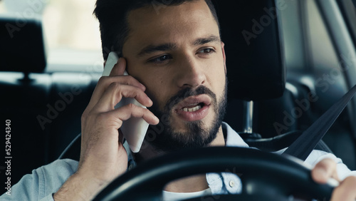 young man traveling in car and talking on mobile phone.