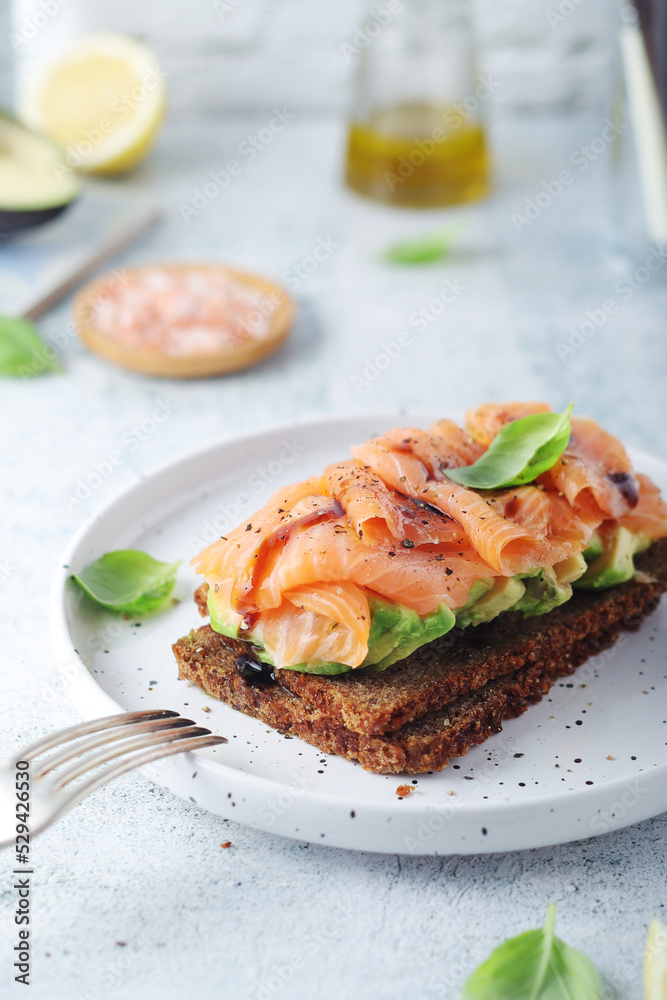 A rye bread sandwich with avocado and salmon