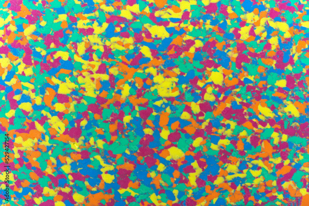 Sponge texture background with a multi coloured textured effect with all the colours of a pattern rainbow such as red, yellow, green, blue, orange and purple, stock photo image