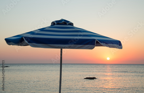 Parasol at sunrise by ocean