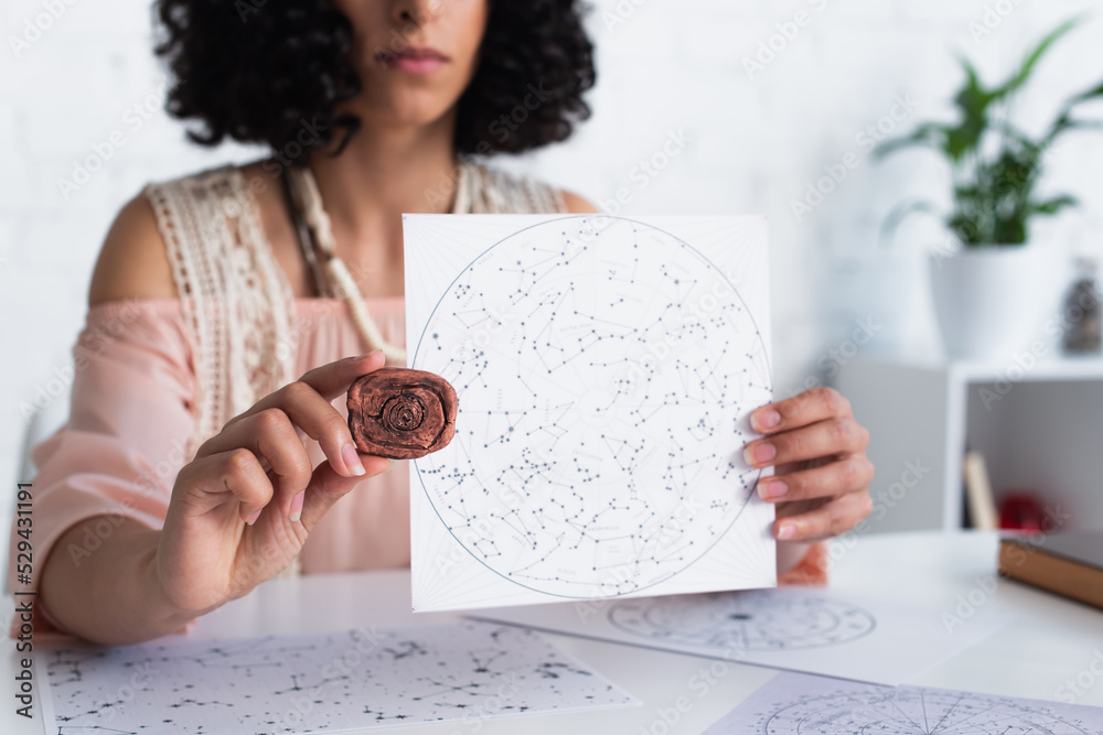 partial view of oracle holding clay rune and constellations map. Stock ...