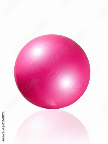 Close-up shot of a pink exercise ball for full body strengthening, yoga and pilates. The non-slip gymnastic ball is isolated on a white background. Front view.