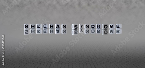 sheehan syndrome word or concept represented by black and white letter cubes on a grey horizon background stretching to infinity