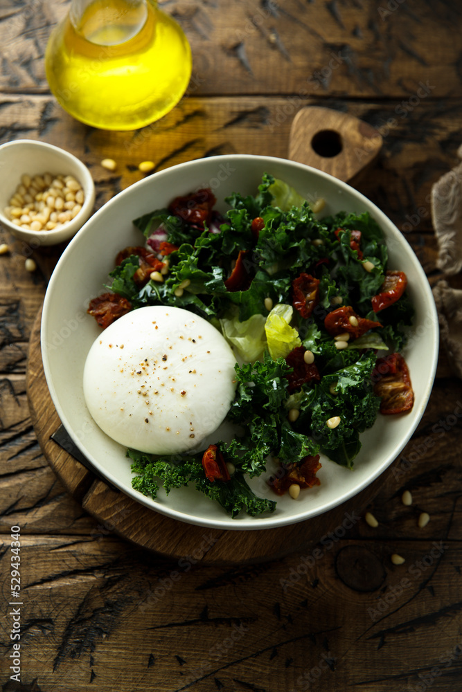 Healthy kale salad with fresh cheese and pine nuts