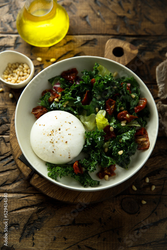 Healthy kale salad with fresh cheese and pine nuts