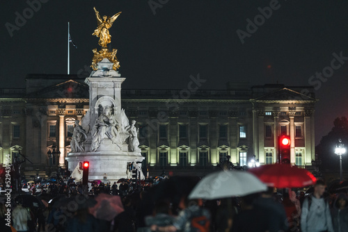People mourn and bring flowers under the rain outside Buckingham Palace after Queen Elizabeth died photo